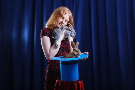 girl shows focus with a rabbit in a hatの写真素材