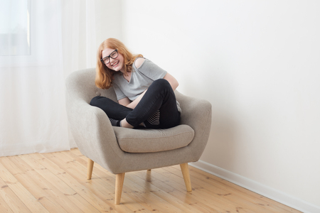 teenager girl in gray armchairの写真素材