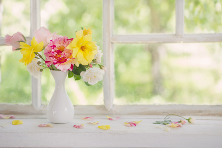 roses oin vase on old windowsillの写真素材