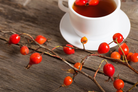 berries of dogrose and tea on wooden backgroundの写真素材