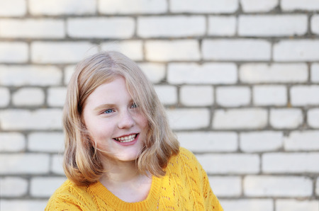 happy teenager girl on background brick wallの写真素材