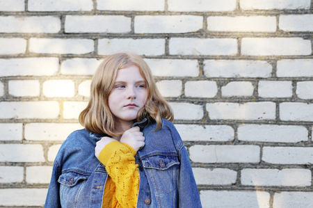 sad teenager girl on background brick wallの写真素材