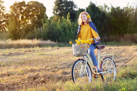 teenager girl on bike in summer fieldの写真素材