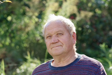 portrait of  elderly man in sunny autumn  park