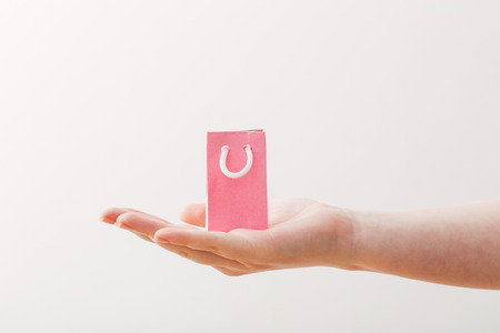 womens hand with paper bag isolated on white backgroundの写真素材