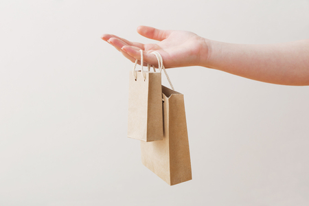 womens hand with paper bag isolated on white backgroundの写真素材