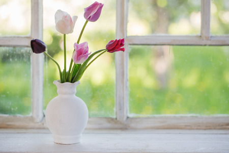 tulips in vase on old windowsillの写真素材
