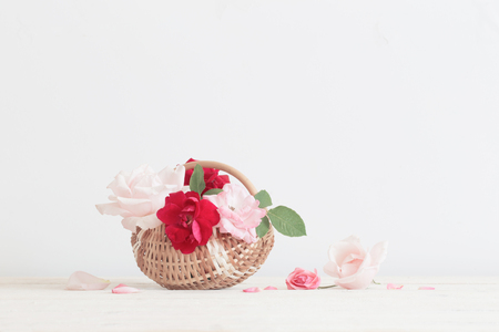 beautiful roses in basket on wooden tableの写真素材