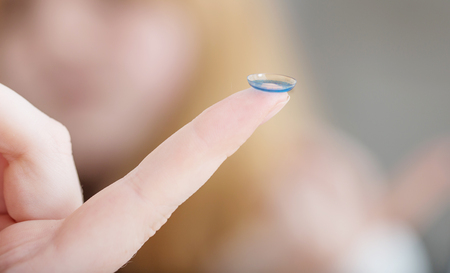 blue eye lens on finger close upの写真素材