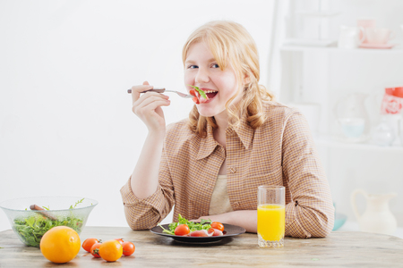 teen girl eats healthy food at homeの写真素材