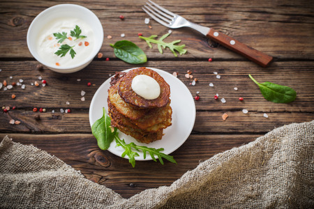 potato pancakes with sour cream on  wooden tableの写真素材