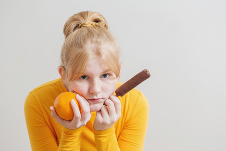 girl with orange and ice cream on white backgroundの写真素材