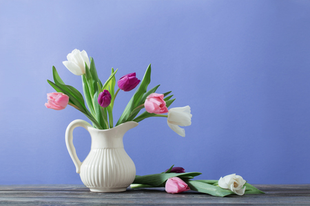 tulips in jug on violet backgroundの写真素材
