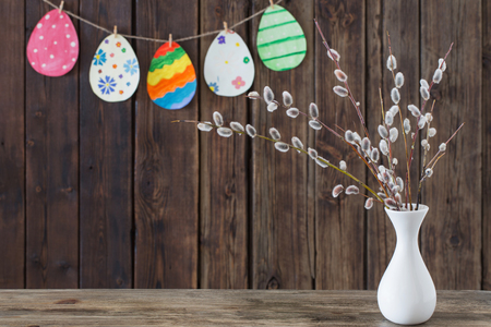 Easter painted paper eggs with branches  willow on wooden backgroundの写真素材