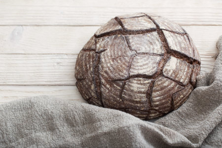 black homemade bread on  white wooden background