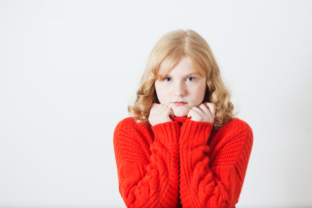 teen girl in red sweater on white backgroundの写真素材