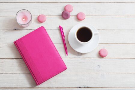 notebook with cup of coffee on white wooden tableの写真素材