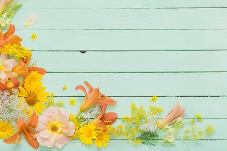 yellow and orange flowers on green wooden backgroundの写真素材