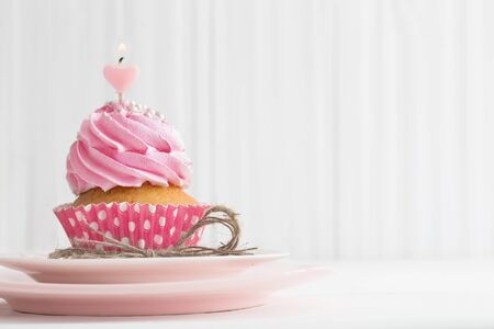 pink cupcake on white wooden backgroundの写真素材