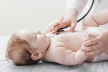 doctor listens to small child with  stethoscopeの写真素材
