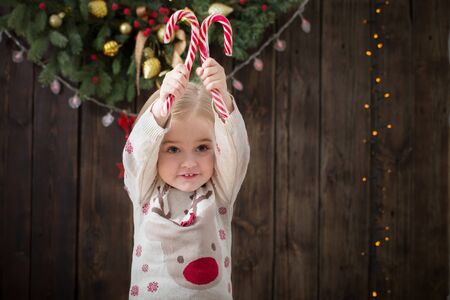 smile little girl with christmas decorations on dark wooden backgroundの写真素材