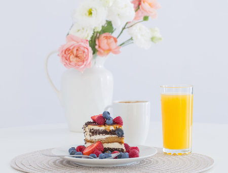 healthy cake  with different berries on plate on white table