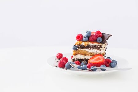 healthy cake  with different berries on plate on white tableの写真素材