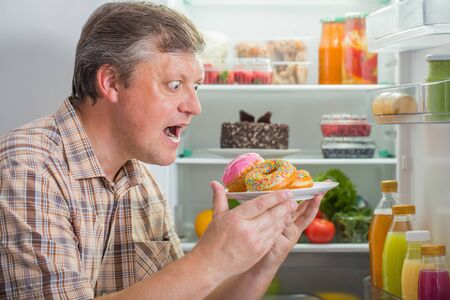 mature men at fridge  with foodの写真素材