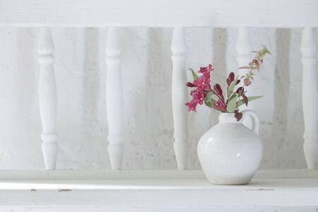 flowers in white vase on old wooden shelfの写真素材