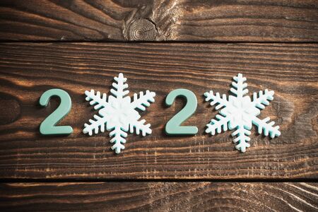New Year composition, 2020 symbols and snowflakes  on old wooden backgroundの写真素材