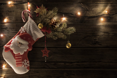 Christmas stocking with gifts hanging on dark old wooden background