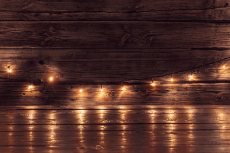 electric garland with yellow light bulbs on a wooden surface, Christmas and New Year background