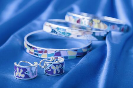 Earrings and bracelet on blue cloth. Classic blue color 2020.の写真素材