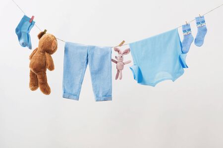 baby clothes hanging on  rope on white backgroundの写真素材