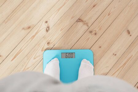 female legs on electronic scales on a wooden floorの写真素材