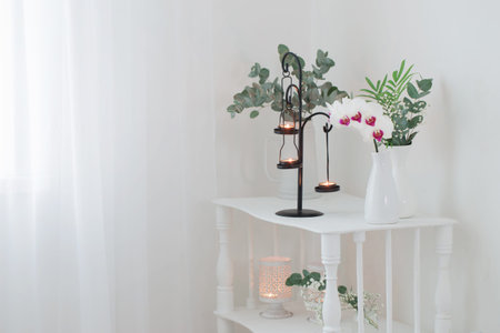 antique candlestick with burning candles and flowers  on white old wooden shelf