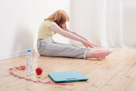 teenage girl doing sports at home, electronic scales on the floor