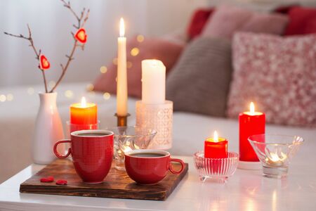 Burning candles on white table in interior. Valentines day conceptの写真素材