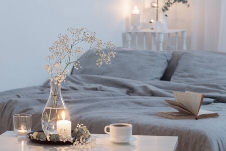 night interior of bedroom with flowers and burning candlesの写真素材