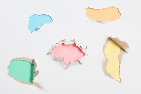 hole in white paper with colored paper backingの写真素材