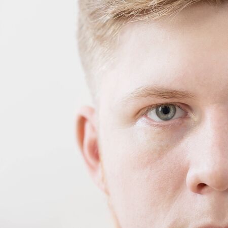 half face of  young man on white backgroundの写真素材