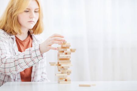 beautiful teenager girl  builds  tower of wooden cubesの写真素材