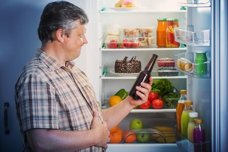 mature men at fridge  with beerの写真素材
