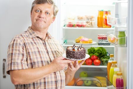 mature men at fridge  with foodの写真素材