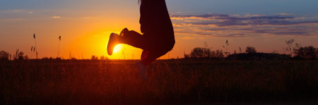 jumping girl in field at sunset