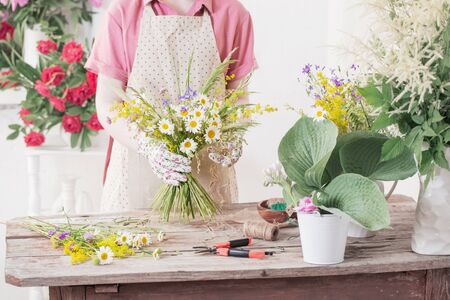 girl florist makes  bouquet of wildflowersの写真素材