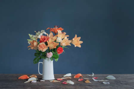 bouquet of lily flowers in white jug on dark blue backgroundの写真素材