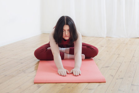 brunette girl doing yoga on floor at home