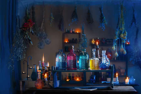 magic potions in witch's house with burning candles at nightの写真素材