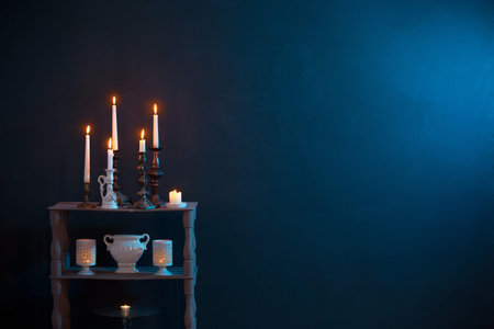 candlesticks with burning candles on dark blue background